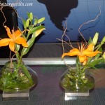 Liliums naranjas en esponja floral cubierta con follaje de helecho y Sauce eléctrico.
